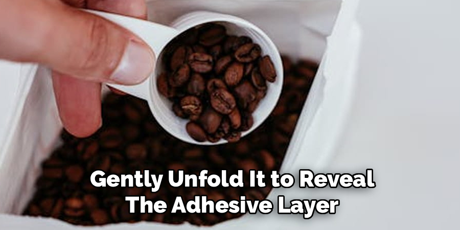 Gently Unfold It to Reveal The Adhesive Layer